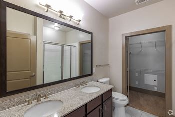 a bathroom with two sinks and a large mirror